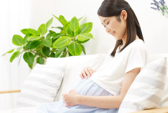 お腹に手をあてている妊婦さん