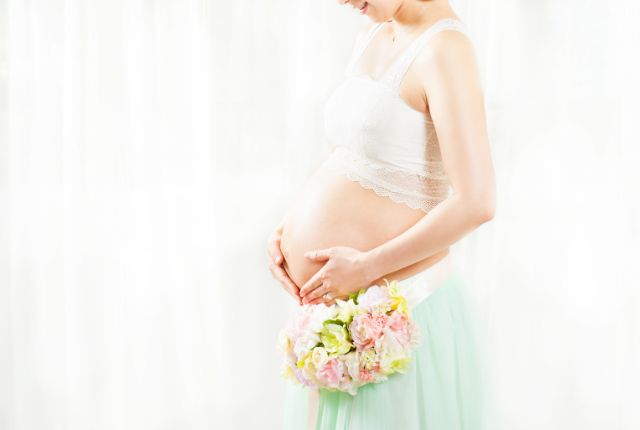 お腹に手をあてている妊婦さん