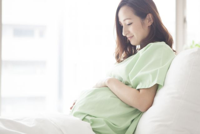 お腹に手をあてている妊婦さん