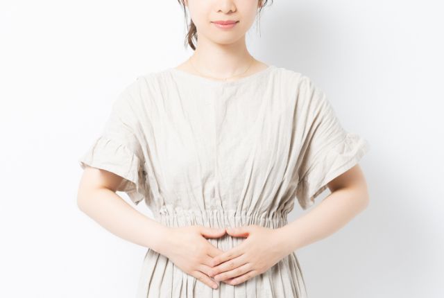 お腹に手をあてている女性
