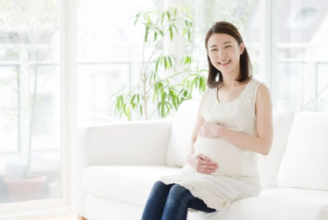お腹に手をあてている妊婦さん